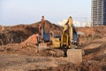 Group of the excavators for dig ground trenching at a construction site for foundation and installing storm pipes Royalty Free Stock Photo