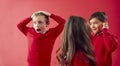 Group Of Excited Elementary School Pupils Wearing Uniform Having Fun Against Red Studio Background Royalty Free Stock Photo