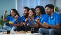 Group of excited Indian cricket fans celebrating by shouting for Team India win in cricket while watching tv at home - Royalty Free Stock Photo