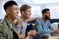 Group Of Excited Male Friends Watching Sports On TV At Home In Lounge Together Royalty Free Stock Photo