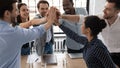 Excited multiethnic staff members giving high five sharing success Royalty Free Stock Photo