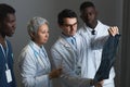 Group of experienced radiologists looking at x-ray image of patient