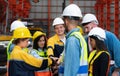 Group of factory workers in hardhats with joint hands together