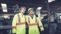 Group of factory workers using machine equipment in factory workshop