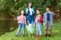 Group family asian children collecting garbage and plastic on the river to dumped into the trash for volunteer charity save enviro