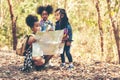 Group family children checking map for explore and find directions in the camping jungle nature and adventure. Royalty Free Stock Photo