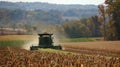 A group of farmers in rural farmland work together to harvest crops using a combine powered by biofuels promoting