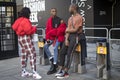 A group of fashionably dressed friends chatting at the entrance to the building