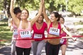 Group Of Female Athletes Completing Charity Marathon Race