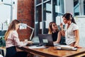 Group of female executives sitting with laptops and documents at desk gathered to discuss problems and plans in a Royalty Free Stock Photo