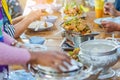 Group of female friends enjoy eating with acacia pennata omelette sour soup in fish shape hot pot in the restaurant. Royalty Free Stock Photo