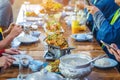 Group of female friends enjoy eating with acacia pennata omelette sour soup in fish shape hot pot in the restaurant. Selective Royalty Free Stock Photo