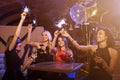 Group of female friends enjoying birthday party having fun with firework sparklers drinking alcoholic cocktails sitting Royalty Free Stock Photo