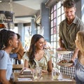 Group Of Female Friends Meeting Up In Restaurant Being Served Meal By Waiter Royalty Free Stock Photo