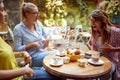 Group of female friends talking in outdoor cafe, showing on their bellies, laughing Royalty Free Stock Photo