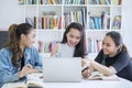 Group of female students using a laptop in library