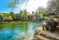 A group of female tourists relax at a riverside cafe table alongside the Kravica or Kravice Falls in Bosnia-Herzegovina