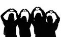 Group of females making love heart symbols with their hands silhouetted