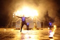 Group of fire jugglers performing at night show on stage, juggling with torches. Kyiv, Ukraine Royalty Free Stock Photo