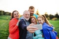 A group of fit and active people resting after doing exercise in nature, taking selfie. Royalty Free Stock Photo