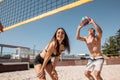 Group of young cheerful people playing beach volleyball on sunny day Royalty Free Stock Photo