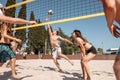 Group of young cheerful people playing beach volleyball on sunny day Royalty Free Stock Photo