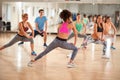 Group of fitness exercisers in colorful sports clothes in fitness class