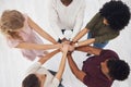 Group of five businesspeople stacking their hands together in an office at work. Business professionals having fun