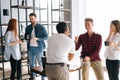 Group of five cheerful young business multi-ethnic startup colleagues enjoying pleasant conversation during coffee break Royalty Free Stock Photo