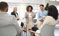 Group of five diverse businesspeople having a meeting in an office at work. Happy mixed race businesswoman reading a Royalty Free Stock Photo