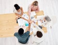 Group of five diverse businesspeople having a meeting at a table in an office from above. Happy business professionals Royalty Free Stock Photo