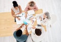 Group of five diverse businesspeople having a meeting at a table in an office from above. Serious business professionals Royalty Free Stock Photo