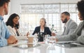 Group of five diverse businesspeople talking in a meeting together at work. Business professionals talking and planning Royalty Free Stock Photo