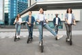 Friends having pleasant ride on motorized kick scooters Royalty Free Stock Photo