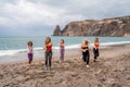 A group of five female friends are doing exercises on the beach. Beach holiday concept, healthy lifestyle Royalty Free Stock Photo