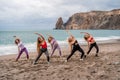 A group of five female friends are doing exercises on the beach. Beach holiday concept, healthy lifestyle Royalty Free Stock Photo