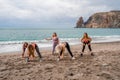 A group of five female friends are doing exercises on the beach. Beach holiday concept, healthy lifestyle Royalty Free Stock Photo