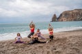 A group of five female friends are doing exercises on the beach. Beach holiday concept, healthy lifestyle Royalty Free Stock Photo