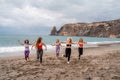 A group of five female friends are doing exercises on the beach. Beach holiday concept, healthy lifestyle Royalty Free Stock Photo