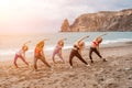 A group of five female friends are doing exercises on the beach. Royalty Free Stock Photo