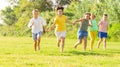 Group of five happy children jogging in a park Royalty Free Stock Photo