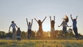 Group of five happy friends jumps at sunset time on background mountains. Royalty Free Stock Photo