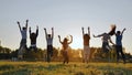 Group of five happy friends jumps at sunset time on background mountains. Royalty Free Stock Photo