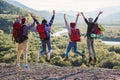 Group of five happy friends jumps at sunset time on background mountains Royalty Free Stock Photo