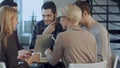 Group of five people discussing something with smile while sitting at the office table Royalty Free Stock Photo