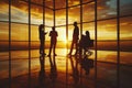 A group of five professionals in a modern office, silhouetted against a sunset window. Reflective floor. Implying