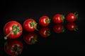 Red cherry tomato isolated on black glass Royalty Free Stock Photo