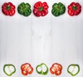Group of five whole peppers and five slices bell pepper. Flat lay on white wooden background