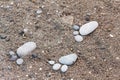 Group of foot by pebble on sand background Royalty Free Stock Photo