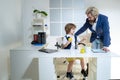 Group of four business colleagues in suits working on project. Little boy playing to be boss on a business desk in Royalty Free Stock Photo